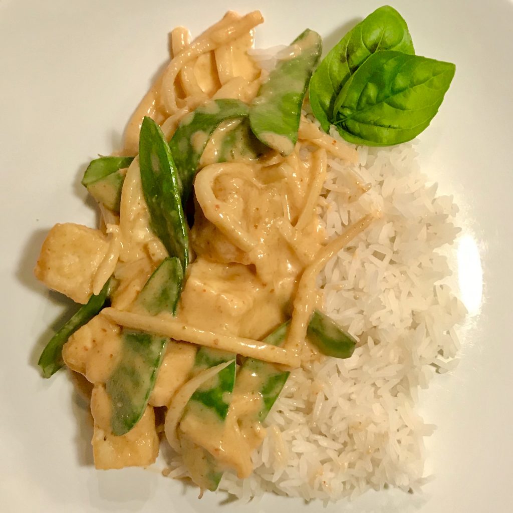 thai red curry with rice on a white plate