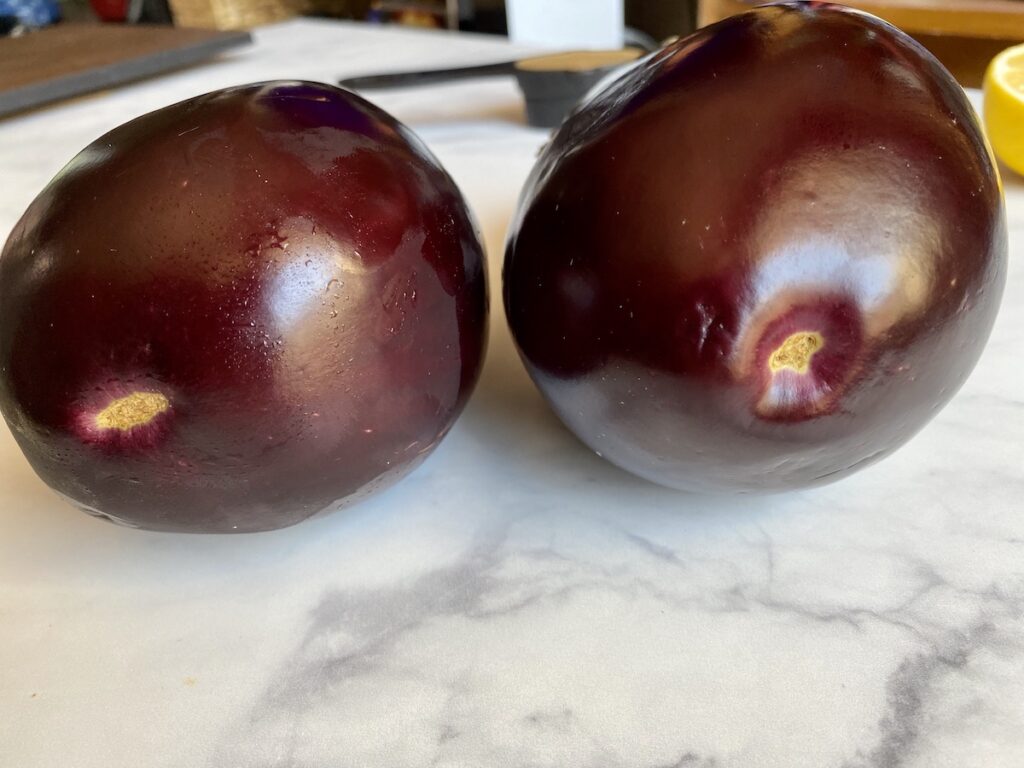 bottom of eggplants that shows male vs. female eggplant comparison