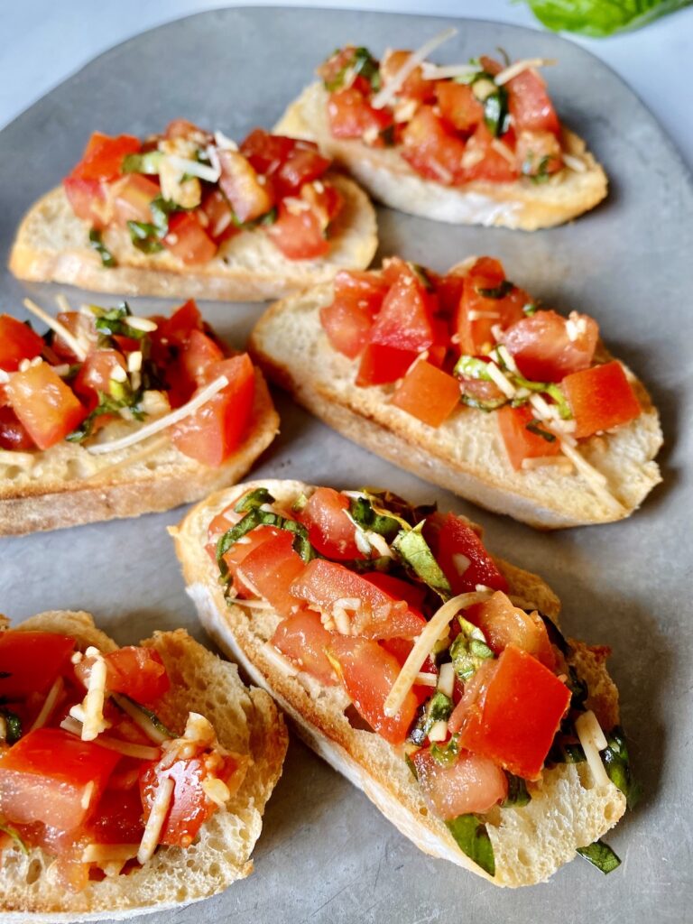 bruschetta crostinis with basil and parmesan on a platter
