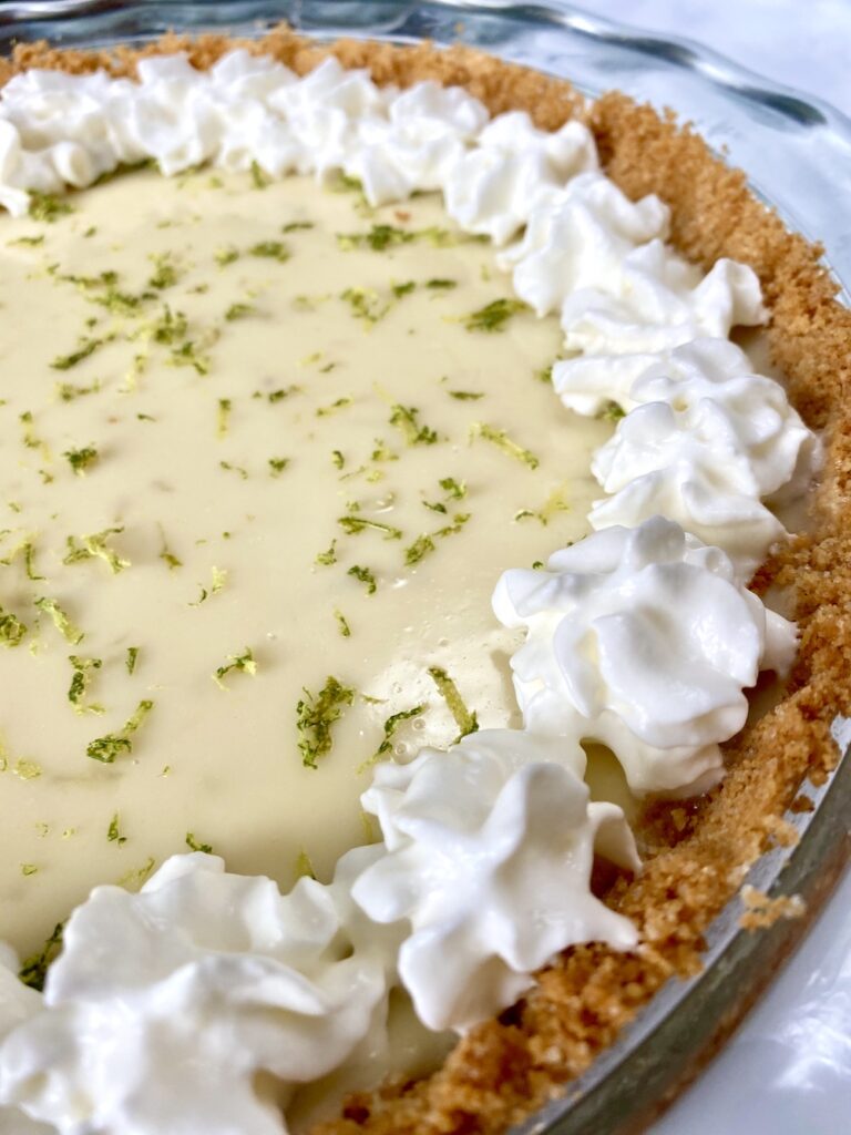 side angle shot of key lime pie with whipped cream